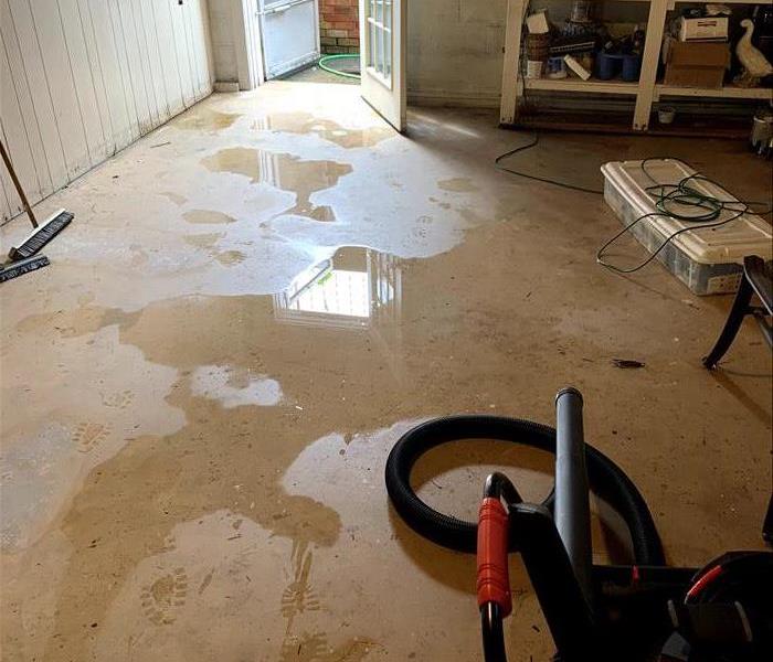 A concrete basement is covered in standing water. 